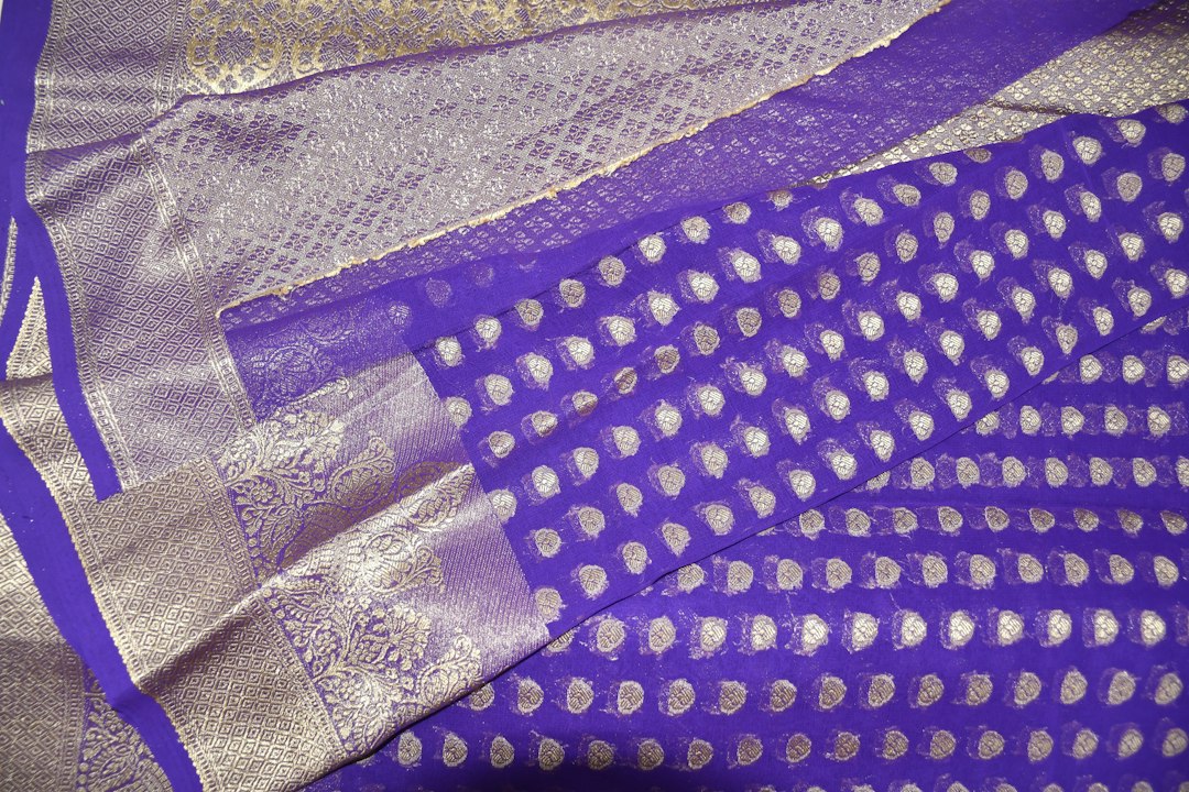 Close-up of a purple silk saree with silver zari work
