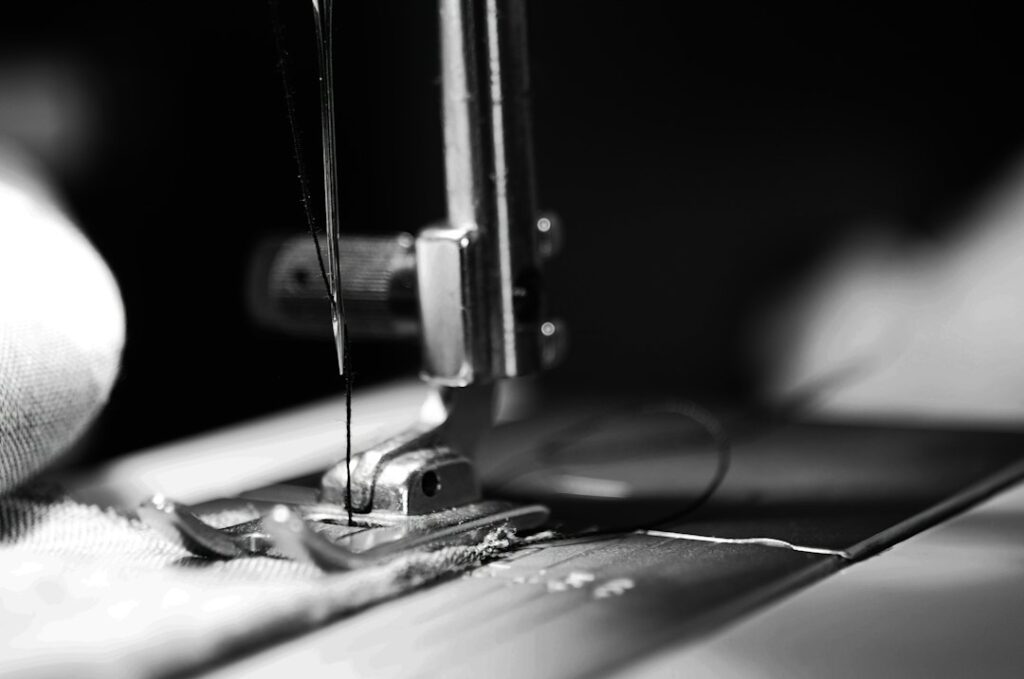 Sewing machine needle stitching fabric in a garment unit