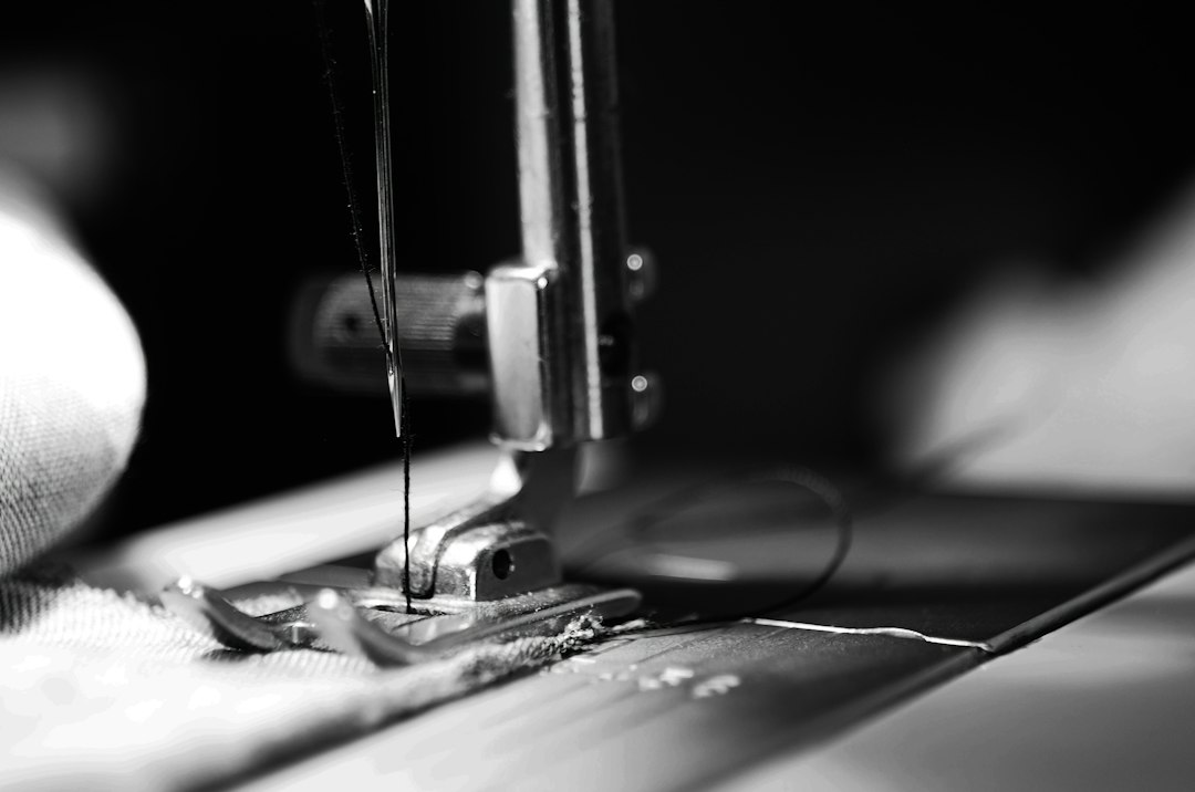 Sewing machine needle stitching fabric in a garment unit